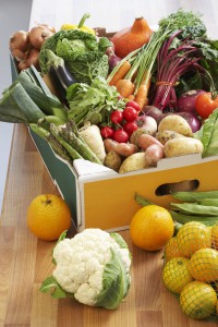 Cardboard box of assorted vegetables on kitchen counter